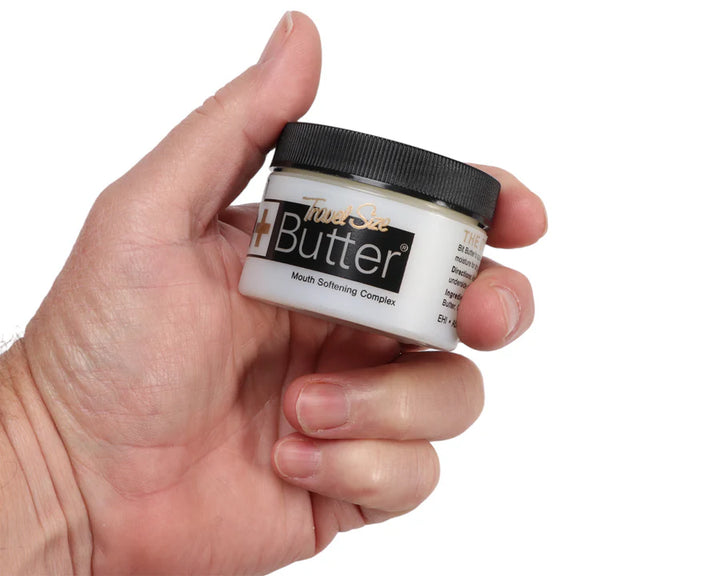 Hand holding a travel-size jar of Original Bit Butter, highlighting its compact design for easy portability.