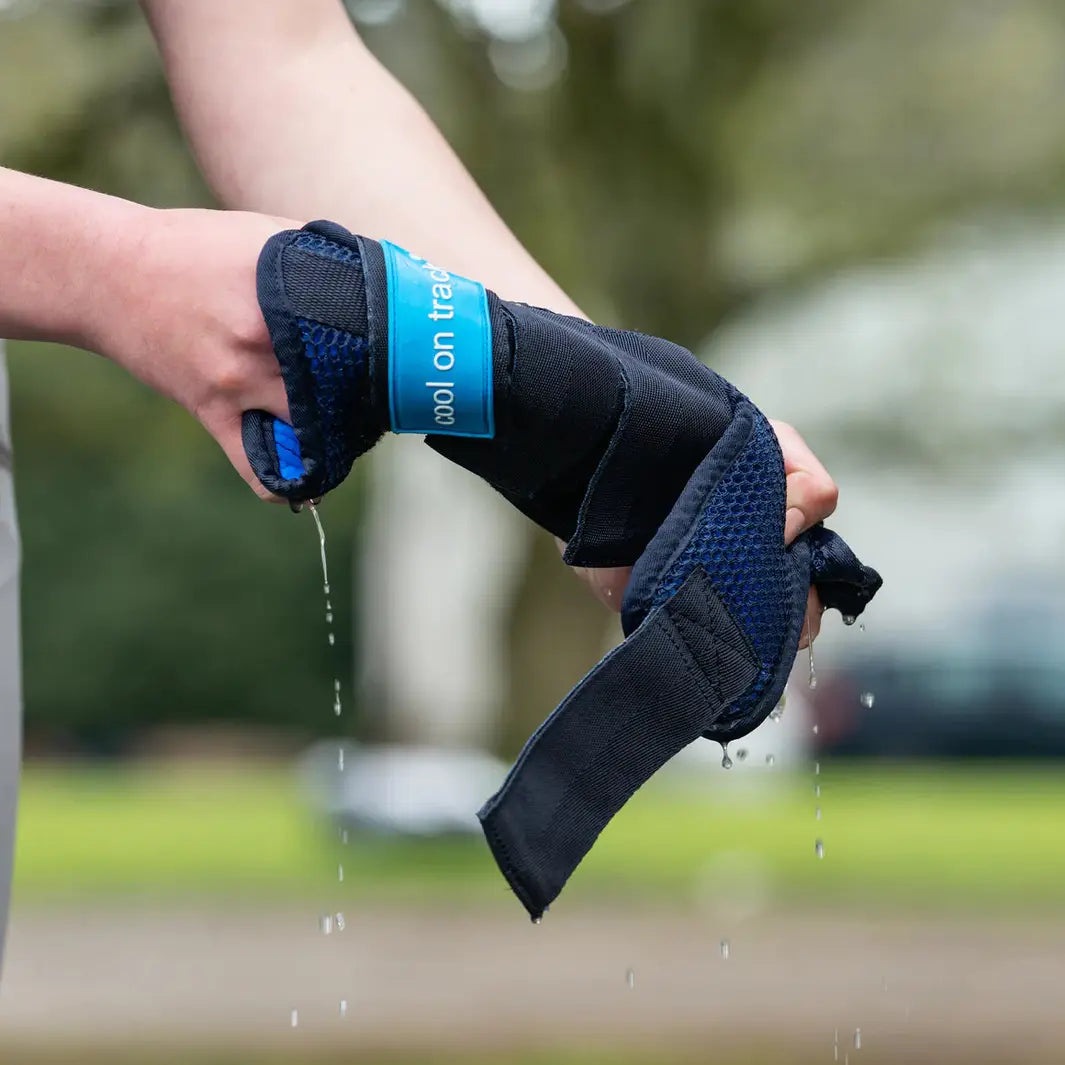 Cool On Track Quick Wrap being wrung out by hand, demonstrating its water-activated cooling function for equine leg recovery and therapy.