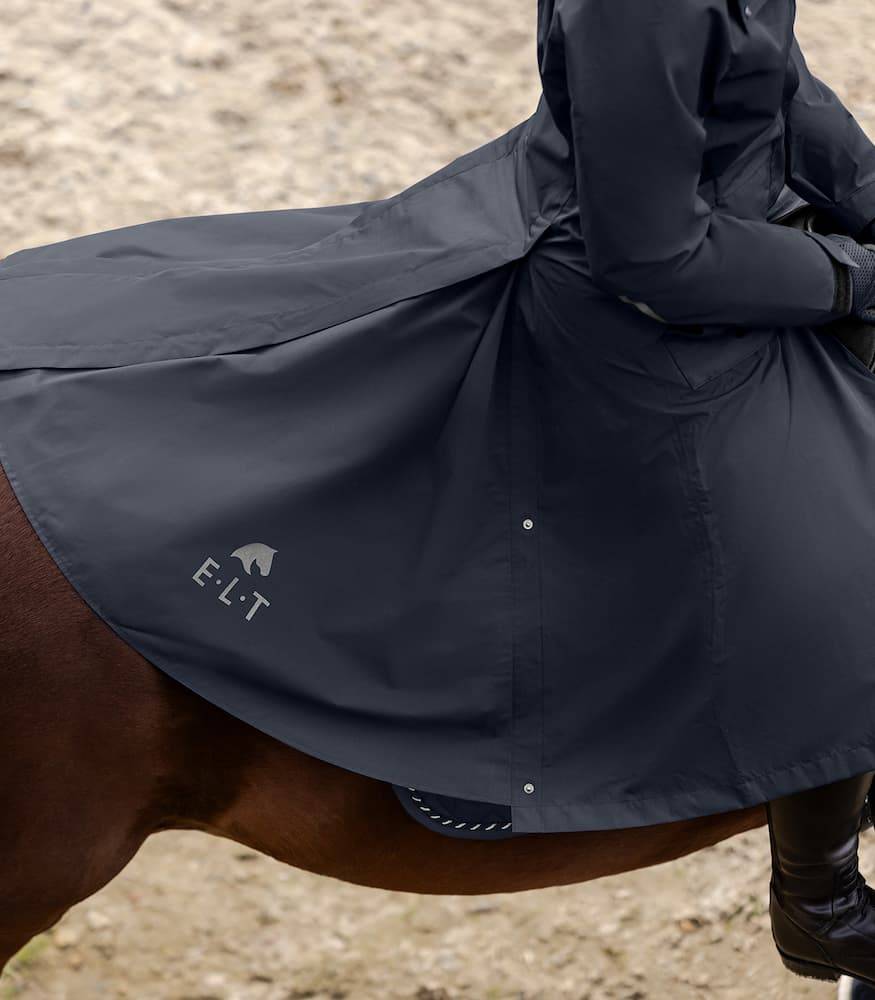 Side view of the ELT Fehmarn Long Riding Raincoat on horseback, showcasing its extended coverage and water-resistant material.