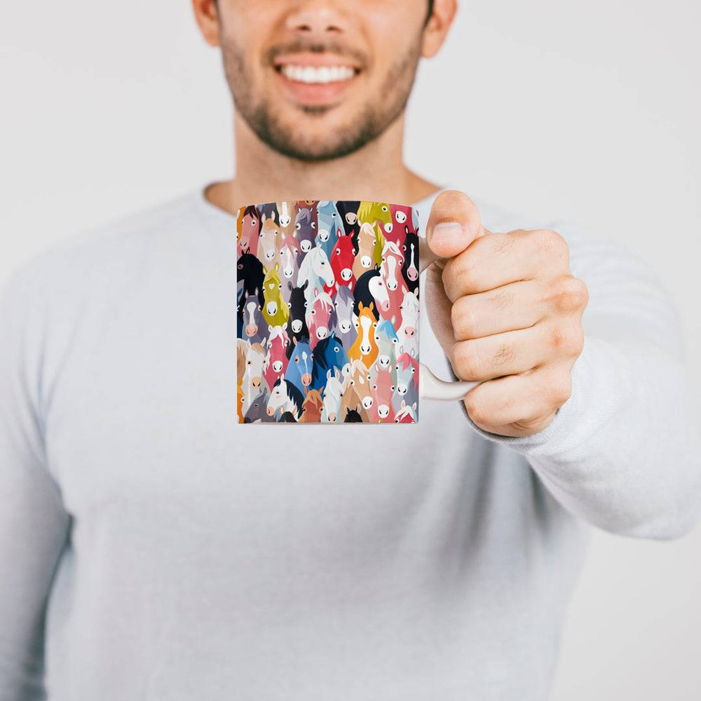 Person holding the Herd of Hues Mug with vibrant horse illustrations, showcasing its 11oz size and equestrian-themed design.