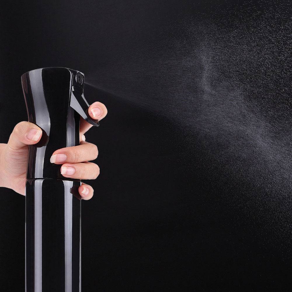 Hand using the Top Paddock Misting Bottle, showcasing its ultra-fine, continuous mist spray for precise equine grooming.
