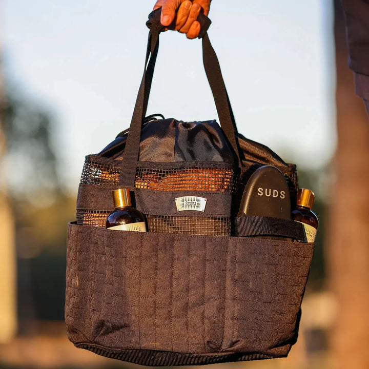 Durable black horse grooming bag with handles, filled with grooming essentials, perfect for equestrian grooming needs.