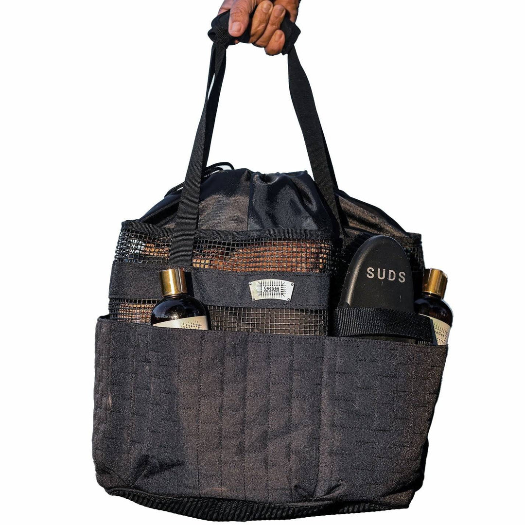 Black horse grooming bag with multiple compartments, holding grooming tools and bottles, designed for equestrian use.