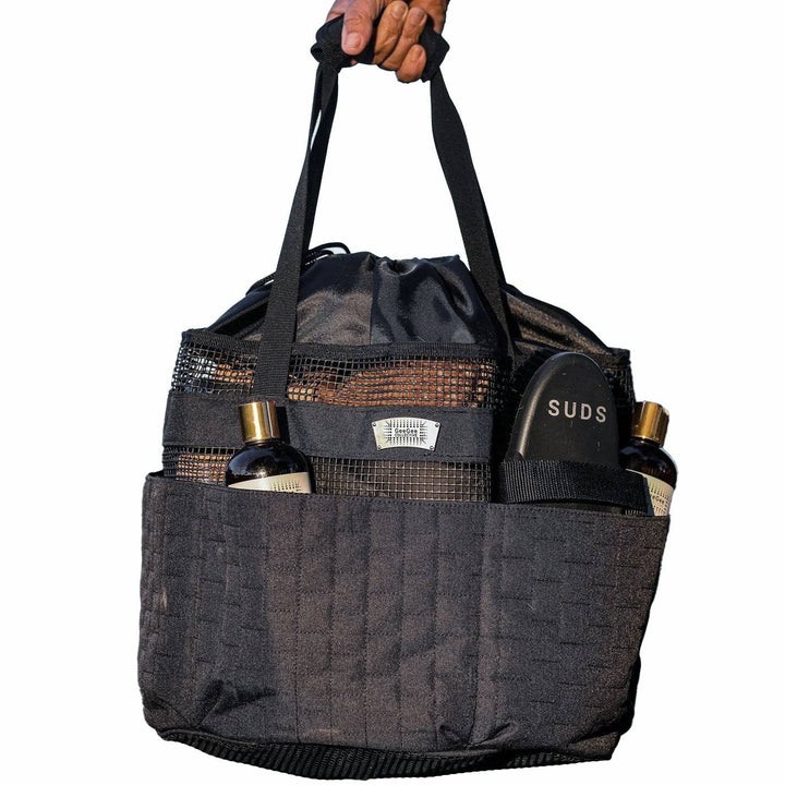 Black horse grooming bag with multiple compartments, holding grooming tools and bottles, designed for equestrian use.