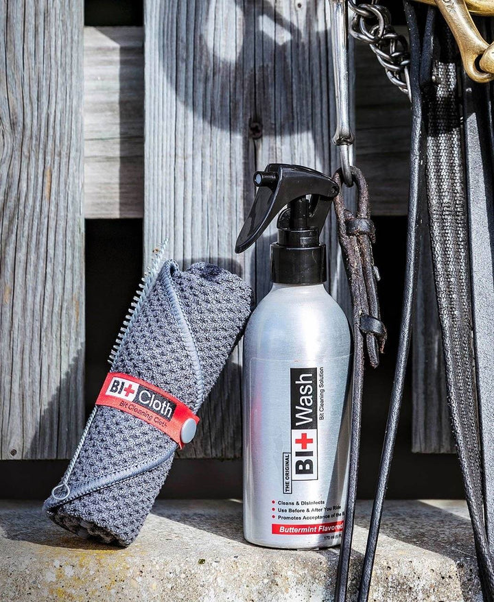 Bit Wash Cleaning Kit displayed with a spray bottle, cleaning cloth, and horse tack, ideal for equestrian grooming and bit care.