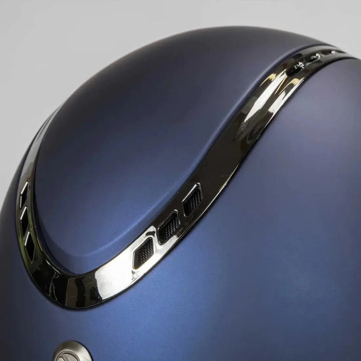 Close-up of the Back On Track EQ3 Pardus Smooth Horse Riding Helmet with MIPS in blue, showcasing the metallic trim and ventilation details.