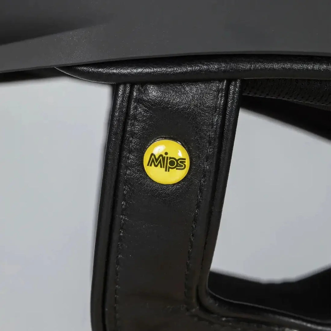 Close-up of the Back On Track EQ3 Pardus Smooth with Sparkle riding helmet featuring the yellow MIPS logo on the leather strap for added safety.