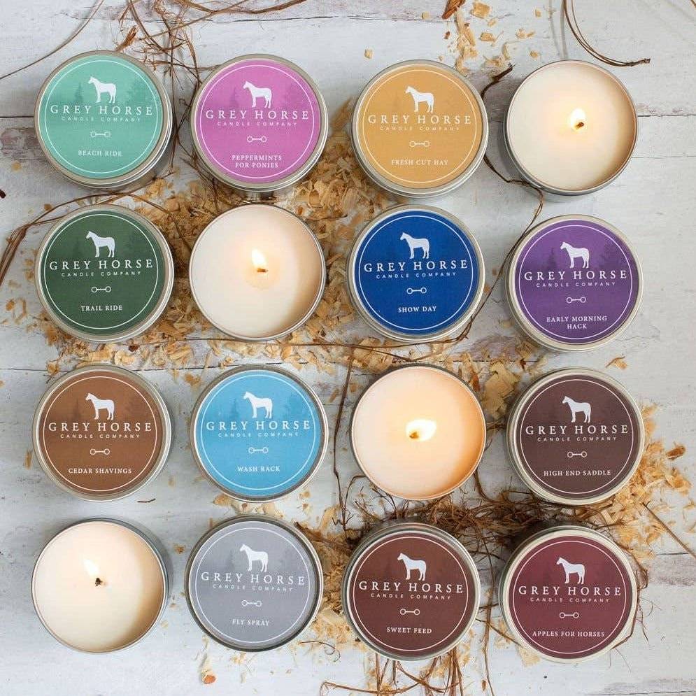 Grey Horse Candles in tins displayed in various colors and fragrances, featuring 17 scent options with natural soy wax and 35-hour burn time.