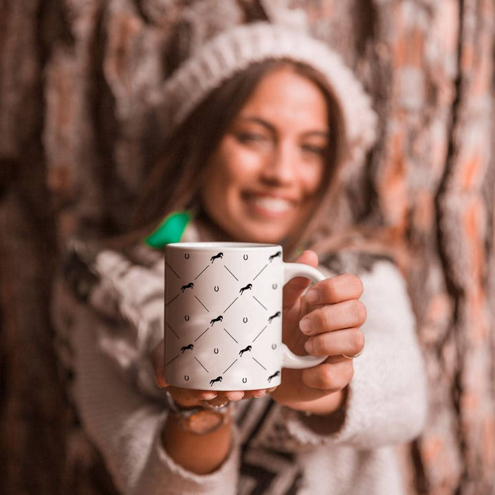 Woman holding the Jumping Star Mug with a black horse and horseshoe pattern, ideal for equestrian-themed gifts and drinkware.