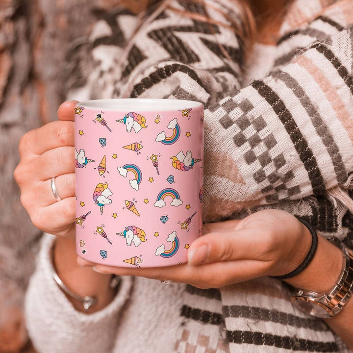 Person holding a Magical Unicorn Mug with a pink background and whimsical unicorn-themed design. Ideal for hot and cold beverages.