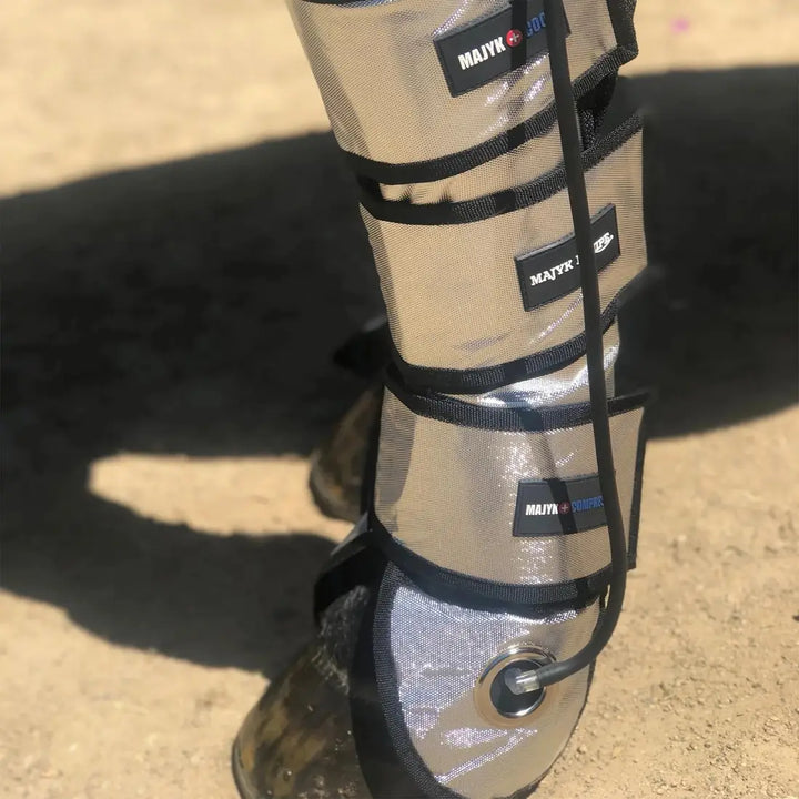 Close-up of Majyk Equipe Cool Compression Gel Ice Boot on a horse's leg, showing reflective material and compression pump attachment.