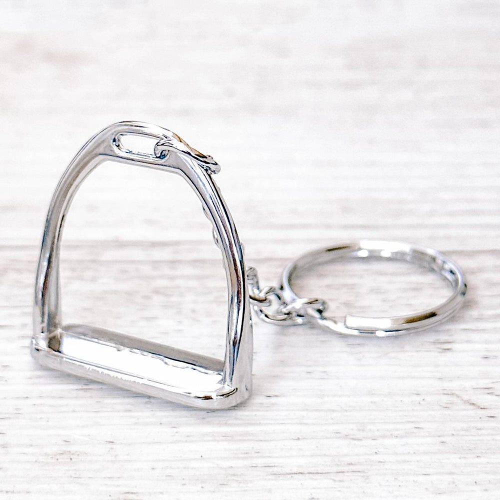 Close-up of a silver stirrup keychain showcasing the detailed stirrup-shaped charm and polished finish.