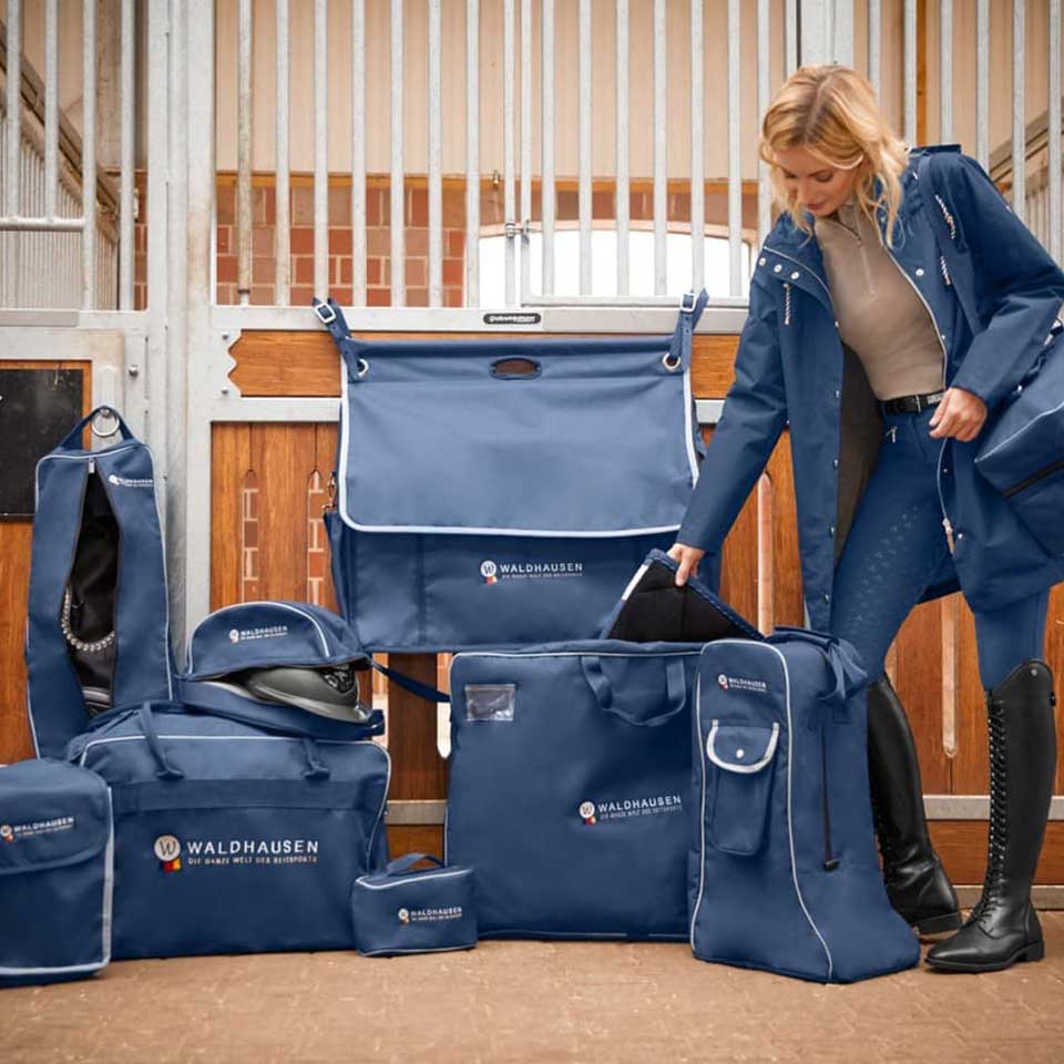 Equestrian Luggage Set by Waldhausen featuring multiple blue horse gear bags, including saddle, boot, and helmet bags, displayed in a stable setting.