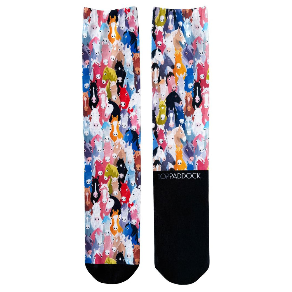 Flat lay of Herd of Hues Youth Riding Socks showcasing vibrant horse-themed design and black accents, ideal for young riders.