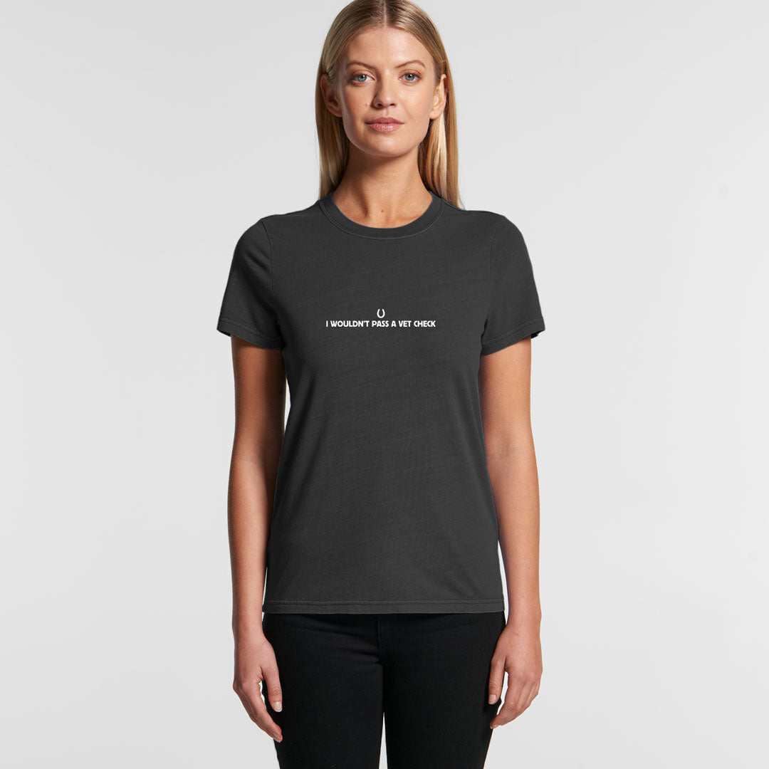 Woman wearing a black 'I Wouldn't Pass A Vet Check' t-shirt with a horseshoe graphic, showcasing a casual equestrian style.