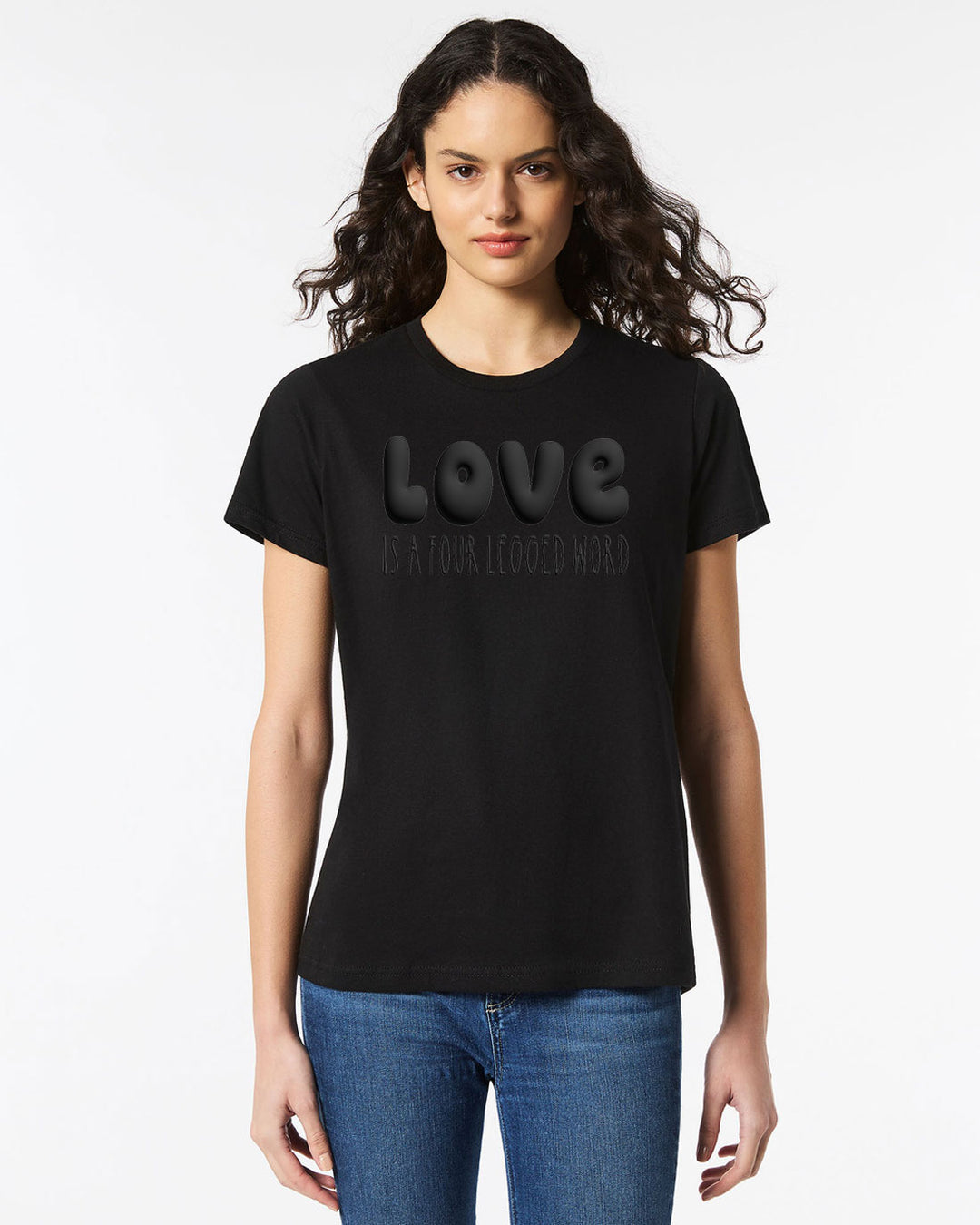 Model wearing the Love Is A Four Legged Word Tee in black with subtle black puffy print text, ideal for equestrian fans.