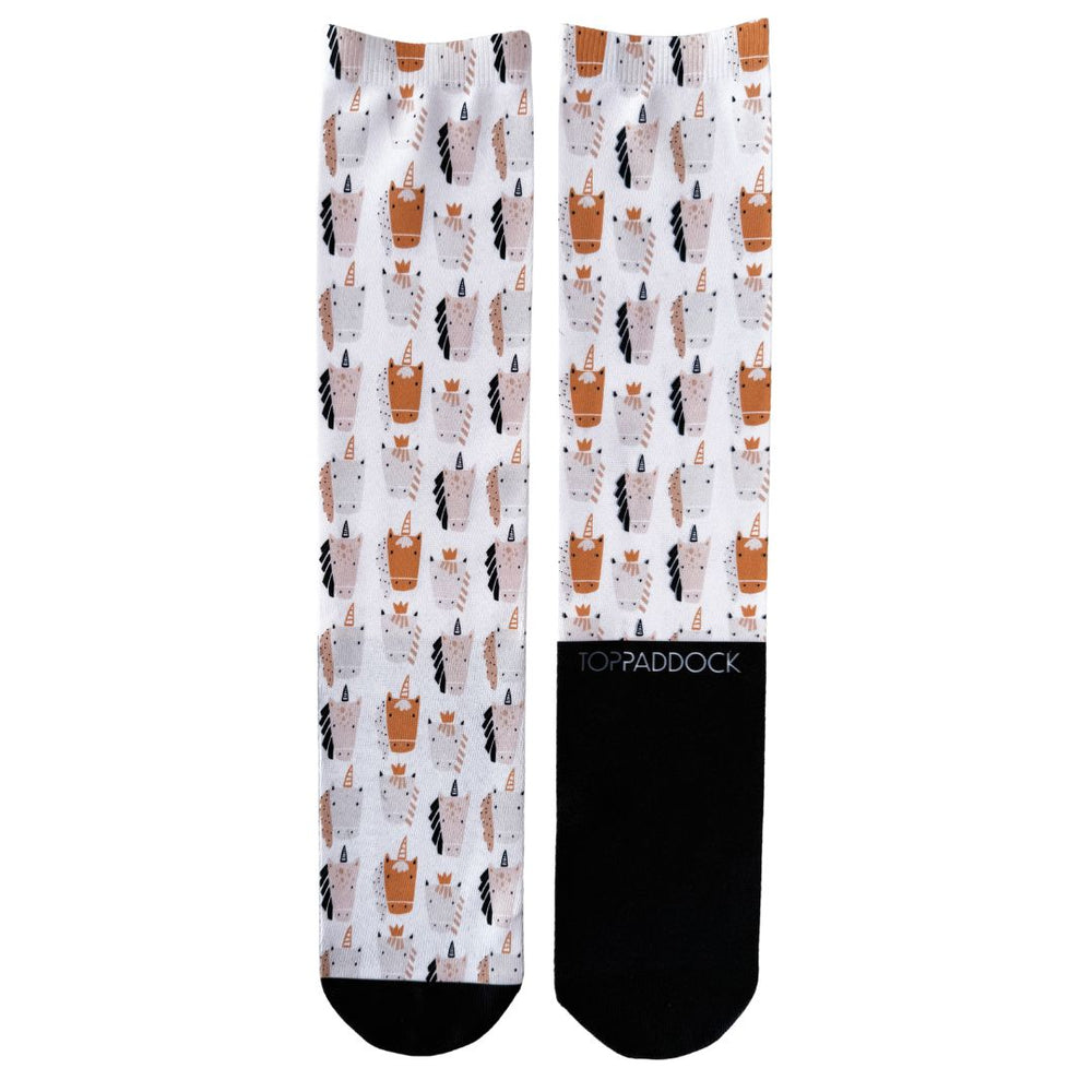 Flat-lay view of Royal Unicorns Youth Riding Socks showcasing a playful unicorn design in beige and black on white fabric, with black accents and 'Toppaddock' branding.