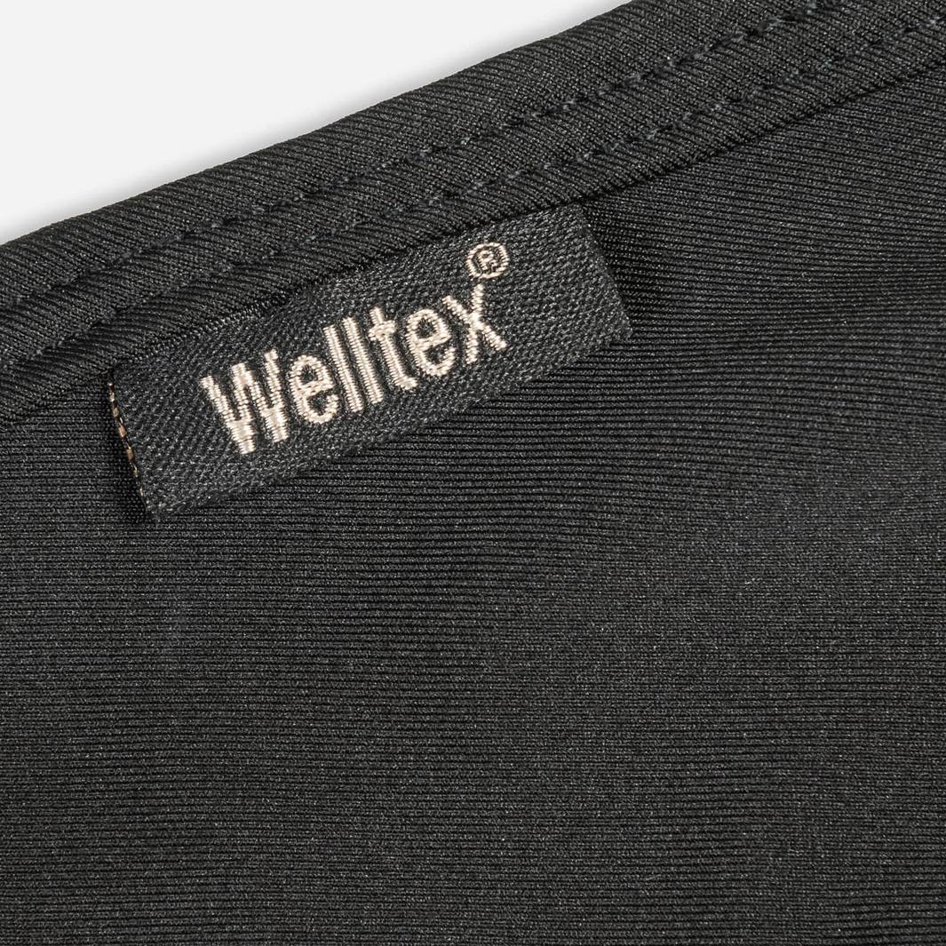 Close-up of the Welltex label on the black therapeutic compression hood, highlighting the patented therapeutic material.