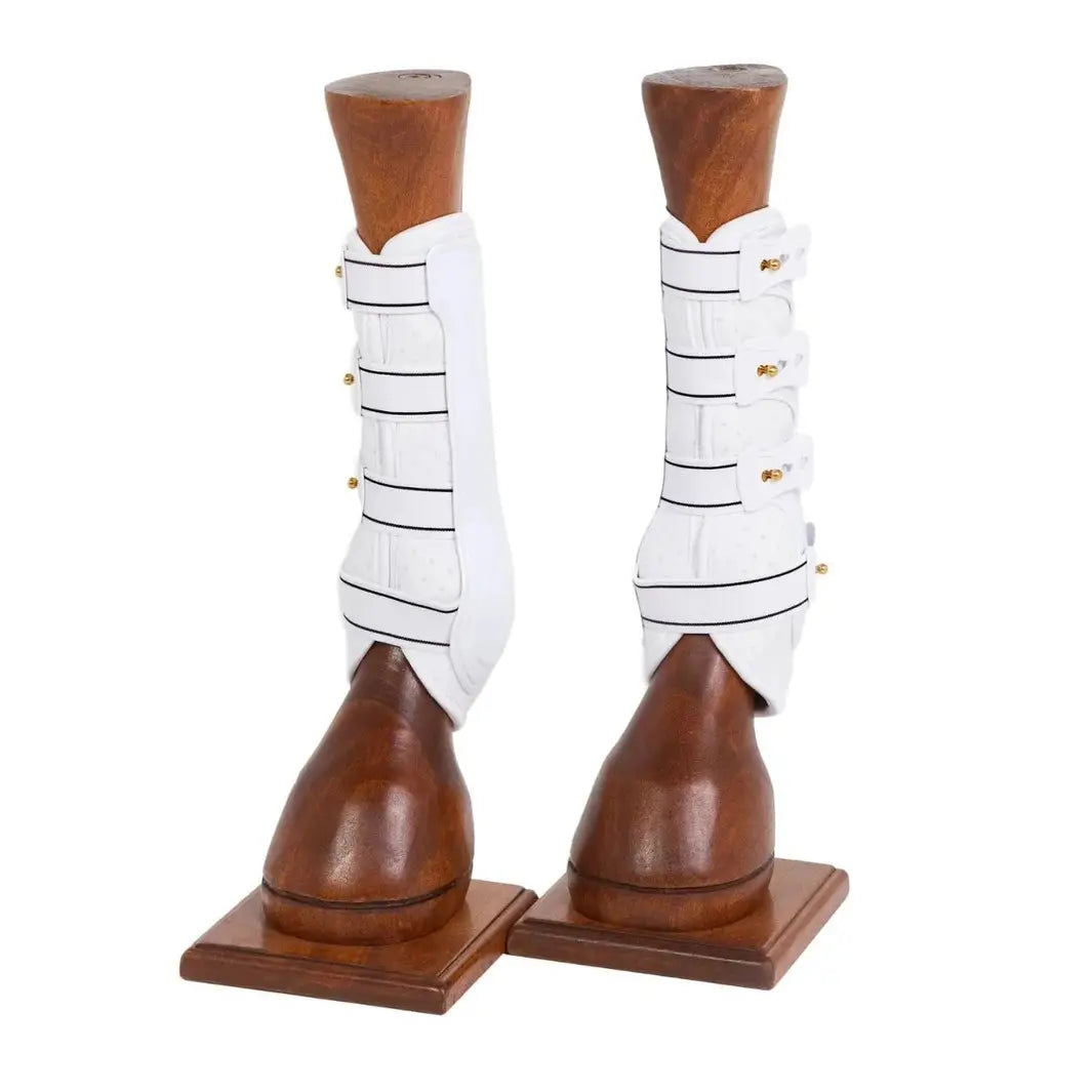 White Royal Dressage Front Boots by Back On Track displayed on wooden horse leg models, showcasing their therapeutic design.